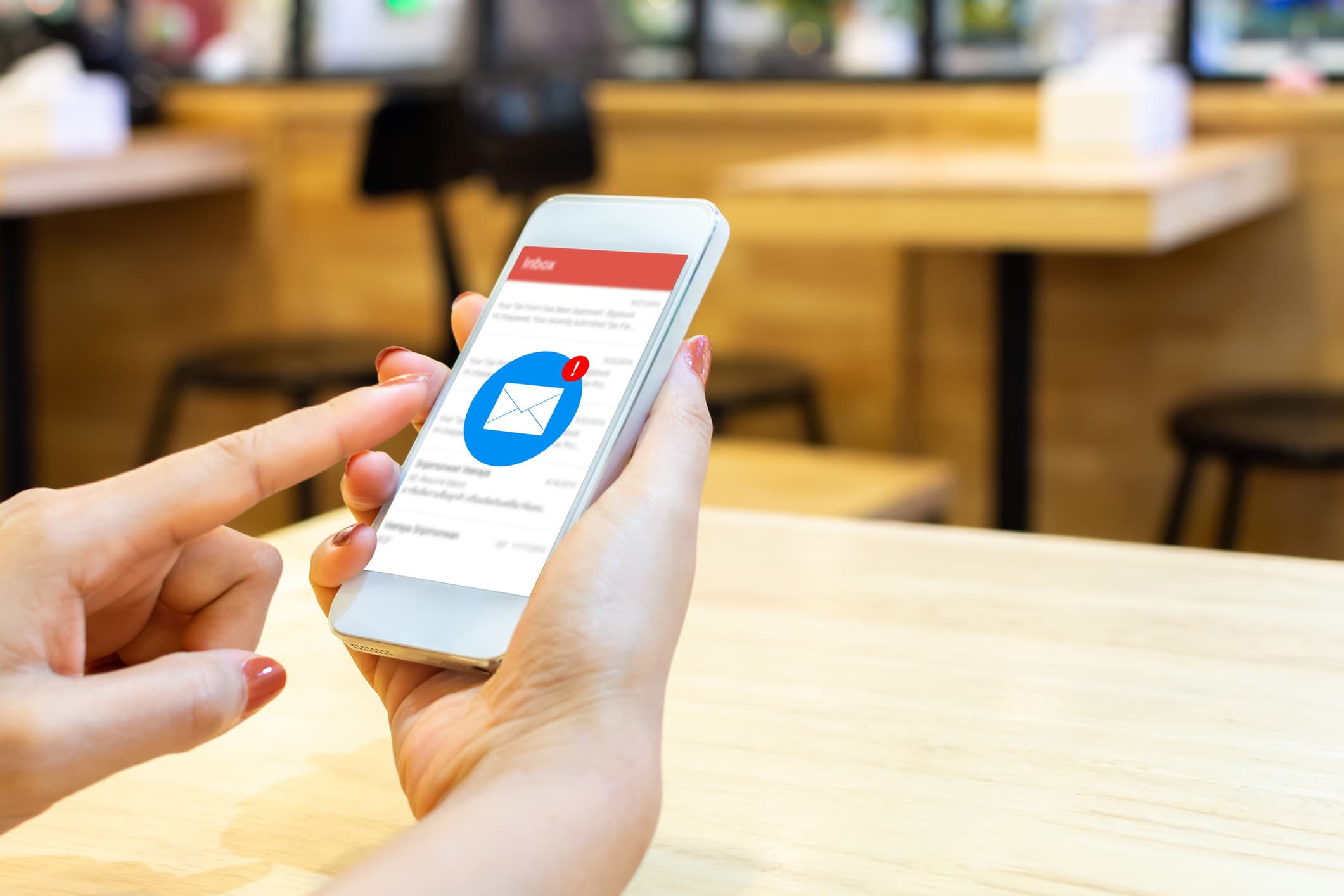 Hands holding a smartphone checking email