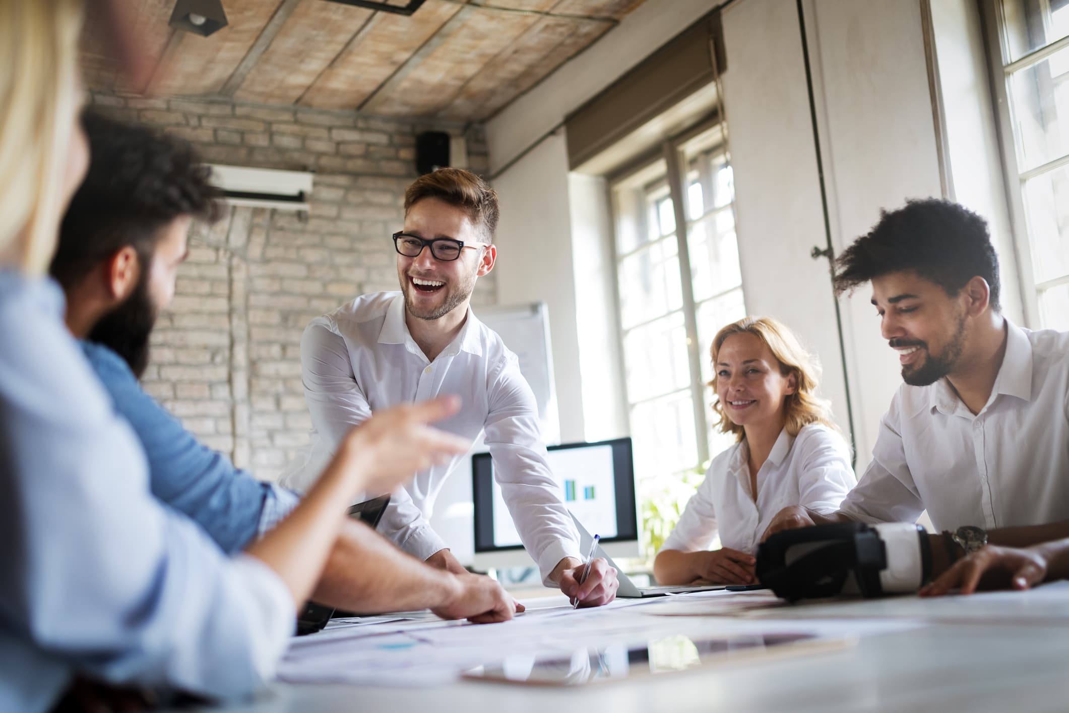 businesspeople smiling around a conference table